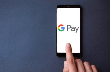 Google Pay. Google ödemeli akıllı telefon ekranında mavi, sarı, siyah arka planda erkek eli ile akıllı telefon. Temmuz 2020. Kiev, Ukrayna.