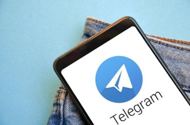 Telgraf var. Telegram akıllı telefon ekranında mavi, sarı, siyah arka planda mavi kot pantolon cebinde. Ukrayna 'nın akıllı telefonunda bir ülke. Temmuz 2020. Kiev, Ukrayna.