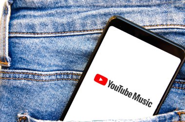 YouTube Müzik. Akıllı telefon ekranında müzik dinlemek için başvuru formu. Siyah arka planda kot pantolon cebinde akıllı telefon. Temmuz 2020. Kiev, Ukrayna.