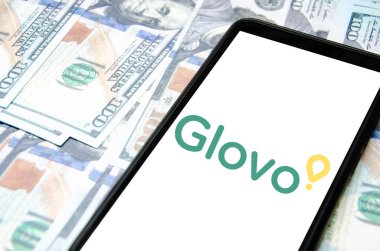 Glovo. Akıllı telefon ekranında Glovo yemek teslimatı. Beyaz arka planda akıllı telefon ve dolar. Temmuz 2020. Kiev, Ukrayna.