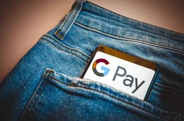 Google Pay. Google 'da mavi kot pantolon cebinde akıllı telefon mavi, sarı, siyah arka planda akıllı telefon ekranı. Temmuz 2020. Kiev, Ukrayna.