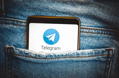 Telgraf var. Telegram akıllı telefon ekranında mavi, sarı, siyah arka planda mavi kot pantolon cebinde. Ukrayna 'nın akıllı telefonunda bir ülke. Temmuz 2020. Kiev, Ukrayna.