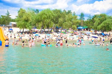 Çok sayıda turistin olduğu bir sahil, sudan bir manzara. Denizin ortasından kumsalın manzarası, su deposu. Temmuz 2020, Kiev, Ukrayna.