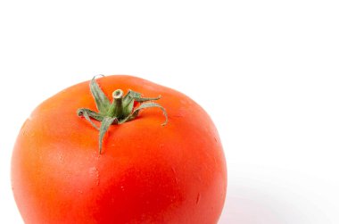 Alt köşede bir kırmızı domates beyaz arka plan ve üst görünümde yeşil bir kuyruk olarak görülüyor..