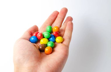 Beyaz arka planda ambalajda M & M var. Kaplama fındıklar beyaz arka plan cc 'sinin üzerine döküldü. M & M 'ler beyaz arkaplan topları üzerinde ve alt görünümde. M & M kesiti. Temmuz 2020. Kiev, Ukrayna