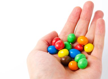 Beyaz arka planda ambalajda M & M var. Kaplama fındıklar beyaz arka plan cc 'sinin üzerine döküldü. M & M 'ler beyaz arkaplan topları üzerinde ve alt görünümde. M & M kesiti. Temmuz 2020. Kiev, Ukrayna