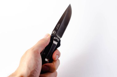 Beyaz arka planı siyah saplı katlanmış bir bıçak, açık ve kapalı. Bıçağın üzerinde paraşüt ipi var. Taktiksel katlama bıçağı yakın planda. Bir adamın elinde bıçak.