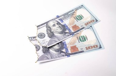 Yanmış dolarlar. Beyaz arkaplan banknotlarında yakın plan olarak yanmış yan görünüm