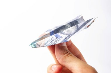 Yanmış dolarlar. Beyaz arka planda yakın plan banknotlarda yanmış bir yan görüntü. Bir adamın elinde beyaz bir arka planda kağıt uçak şeklinde dolarlar.