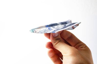 Yanmış dolarlar. Beyaz arka planda yakın plan banknotlarda yanmış bir yan görüntü. Bir adamın elinde beyaz bir arka planda kağıt uçak şeklinde dolarlar.
