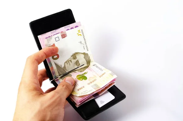 Banknotlar Ukrayna Hryvnia 'sı ve yakın plan beyaz bir arka plan üzerine dolar. Para siyah cüzdanda, para klipsli dolarlar ve Hryvnia