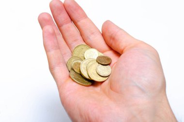 Yakın planda beyaz arka planda Ukrayna sikkeleri. Düşen bir piramit şeklinde, bir adamın elinde, bir yığın yakın plan madeni paralar.