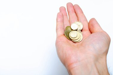 Yakın planda beyaz arka planda Ukrayna sikkeleri. Düşen bir piramit şeklinde, bir adamın elinde, bir yığın yakın plan madeni paralar.