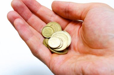 Yakın planda beyaz arka planda Ukrayna sikkeleri. Düşen bir piramit şeklinde, bir adamın elinde, bir yığın yakın plan madeni paralar.