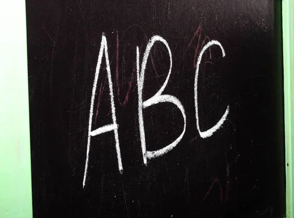 教育委員会 アルファベットが書かれているボード 追加の例 ボードをラグで拭きます 学校の理事会からチョークで手の指 — ストック写真