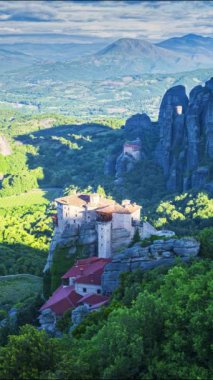 Gün doğumunda Meteora vadisinin dikey görünümü, rousanou manastırı ve St Nicholas Anapausas manastırı üzerinde çalışan gölgeler ile, Kastraki, Kalambaka, Thessaly, Yunanistan - timelapse, dikey