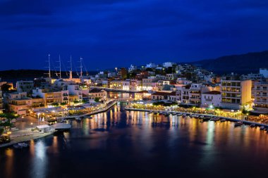 Yunanistan 'ın Girit adasındaki Voulismeni gölü ve Agios Nikolaos kasabasının alacakaranlıktaki renkli manzarası