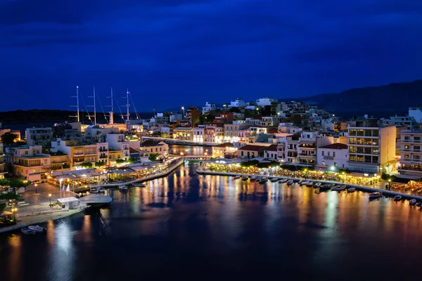 Yunanistan 'ın Girit adasındaki Voulismeni gölü ve Agios Nikolaos kasabasının alacakaranlıktaki renkli manzarası