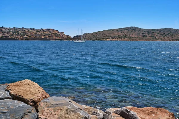 希腊克里特岛斯皮纳隆加岛泻湖和威尼斯要塞的景色，那里有停泊游艇和防波堤石 — 图库照片