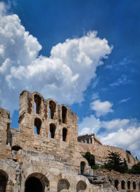 Acropolis Hill, Atina, Yunanistan 'daki Herodes Atticus Tiyatrosu' nun parlak mavi gökyüzü ve süper bulutlardaki görüntüsü. Klasik antik Yunan tiyatrosu kalıntıları