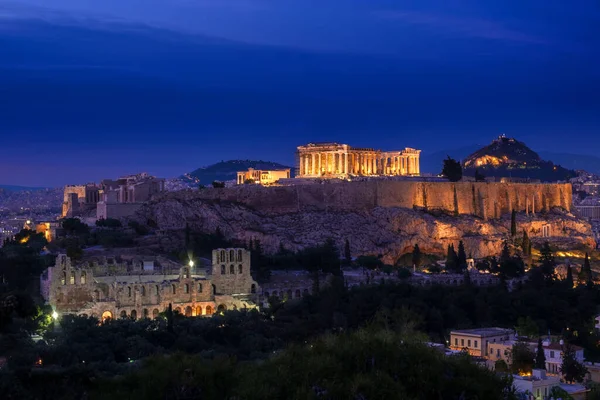 Ikonische Ansicht der Akropolis in Athen, Griechenland bei Nacht. Zarte Lichter des Parthenon und des Odeontheaters. UNESCO-Welterbe. — Stockfoto