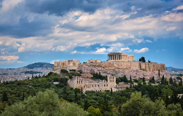 Blick auf den Hügel der Akropolis und das Theater des Odeons in Athen, Griechenland vom Hügel Philoppapos oder Musen im Sommertaglicht mit großen Wolken am blauen Himmel. — Stockfoto