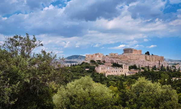 Blick auf den Hügel der Akropolis und das Theater des Odeons in Athen, Griechenland vom Hügel Philoppapos oder Musen im Sommertaglicht mit großen Wolken am blauen Himmel. — Stockfoto