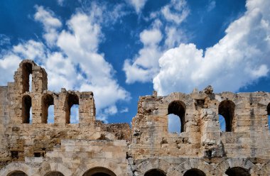 Acropolis Hill, Atina, Yunanistan 'daki Herodes Atticus Tiyatrosu' nun parlak mavi gökyüzü ve süper bulutlardaki görüntüsü. Klasik antik Yunan tiyatrosu kalıntıları