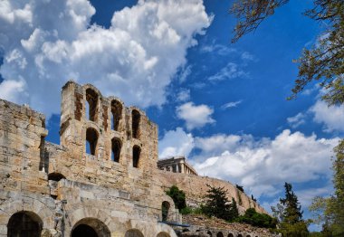 Acropolis Hill, Atina, Yunanistan 'daki Herodes Atticus Tiyatrosu' nun parlak mavi gökyüzü ve süper bulutlardaki görüntüsü. Klasik antik Yunan tiyatrosu kalıntıları