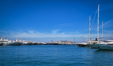 Tekneler ve yatlar bir marinaya demirlemiş ya da demirlemiş ve parlak bir yaz gününde gezinti güvertesine çıkmışlar. Güzel deniz manzarası. Boş zaman, gezi, tatil.. 