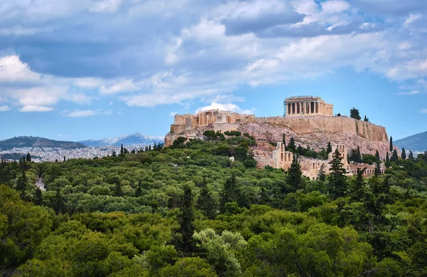 Blick auf den Hügel der Akropolis und das Theater des Odeons in Athen, Griechenland vom Hügel Philoppapos oder Musen im Sommertaglicht mit großen Wolken am blauen Himmel. — Stockfoto
