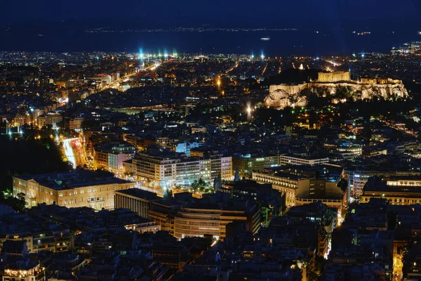Atina ve Akropolis, Parthenon ve Erechtheion 'un gece görüşü, şehir ışıklarında Yunan Parlamentosu. UNESCO dünya mirası sahasının ünlü ikonik görüntüsü.