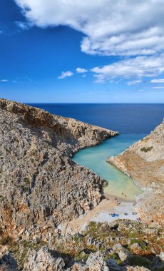 Z şeklindeki körfezin dikey görüntüsü, tipik Yunan güneşli manzarası. Büyük mavi gökyüzü, güzel bulutlar. Seitan Limania, Akrotiri, Chania, Girit Adası, Yunanistan