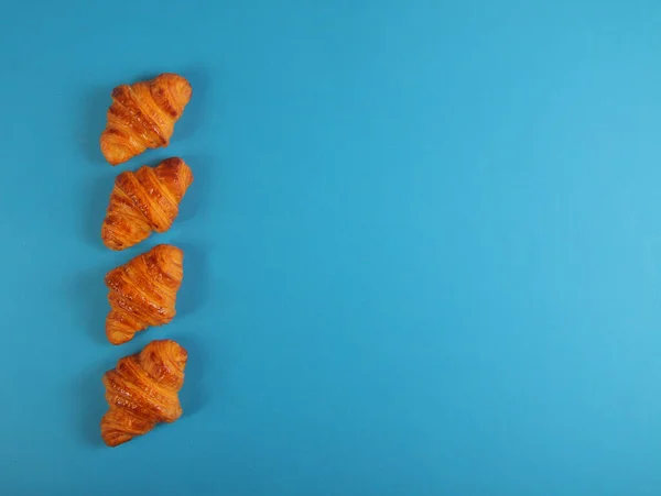 Fyra Croissanter Isolerade Blå Bakgrund Platt Låg Bilden Innehåller Kopieringsutrymme — Stockfoto