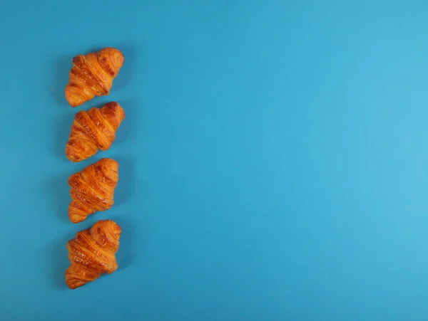 Quatro Croissants Isolado Fundo Azul Flat Lay Imagem Contém Espaço — Fotografia de Stock