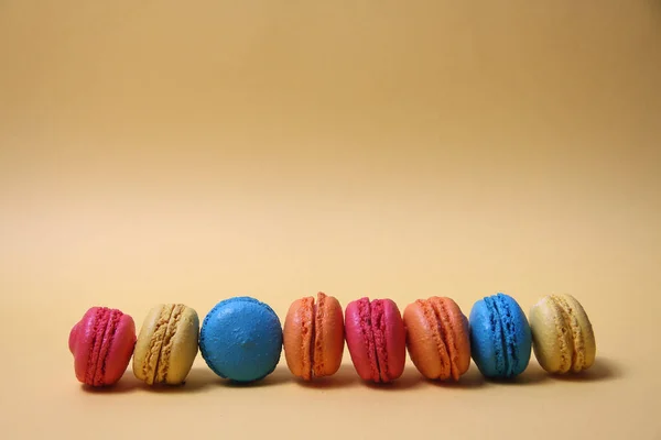 Macarons Van Verschillende Kleuren Een Lijn Geïsoleerd Gele Achtergrond Afbeelding — Stockfoto