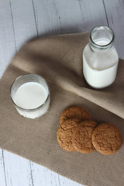 Μπισκότα Ένα Μπουκάλι Και Ένα Ποτήρι Γάλα Χαρτοπετσέτα Λευκό Ξύλινο — Φωτογραφία Αρχείου