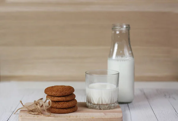 Cookie Egy Üveg Tej Egy Pohár Tej Vágódeszkán Fehér Asztalon — Stock Fotó