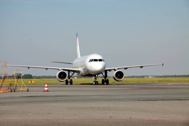 Parlak mavi gökyüzüne karşı taksiyoldaki uçak. Ulaşım kavramı