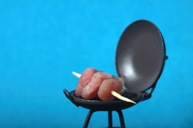 Kızartma makinesinde ızgara et. Mavi arka planda izole edilmiş. Yakın plan. Resim kopyalama alanı içeriyor