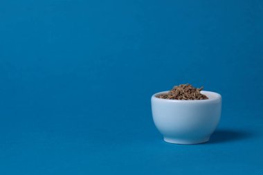 Mavi arka planda beyaz kimyon kasesi. Resim kopyalama alanı içeriyor