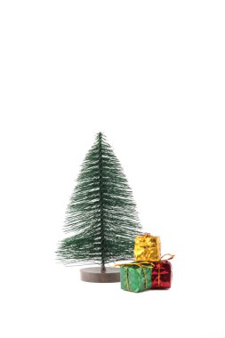 Noel hediyelerini beyaz arka planda izole edilmiş bir köknar ağacının altına sardım. Noel hediyesi konsepti. Dikey görüntü. Resim kopyalama alanı içeriyor