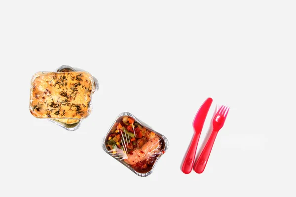 配達メニューのコンセプト ホイルボックス 赤いナイフ 白い背景フラットレイにフォーク 有機的な毎日の食事 コピースペースを奪う — ストック写真