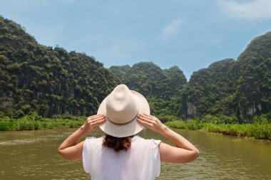 Arkadan görünüm genç kadın adalar arasında Nehri üzerinde tekne ile yolculuk