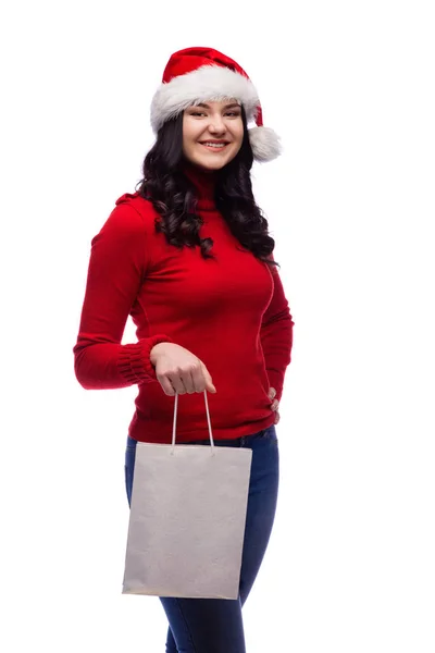 若いブルネットの女性は 幸せそうな顔でプレゼント袋を保持しているクリスマス帽子をかぶっています 白い背景に分離 — ストック写真
