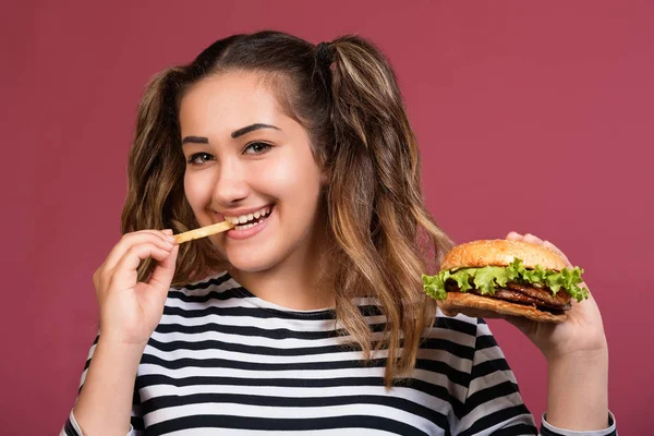 여자는 햄버거를 먹는다 화려한 패스트 푸드와 초상화 여자를 닫습니다 — 스톡 사진