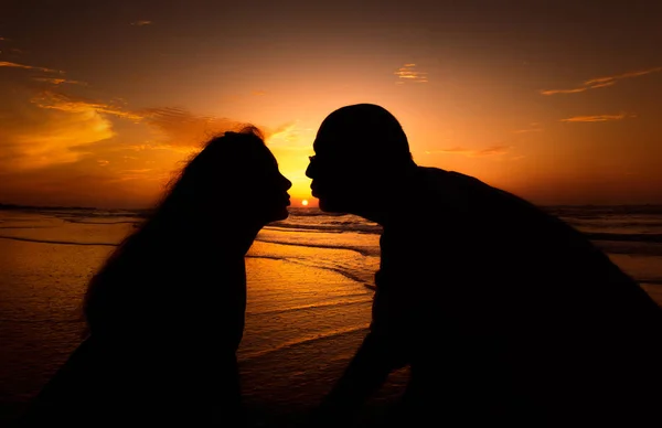 Silueta pareja besándose sobre la puesta del sol fondo —  Fotos de Stock