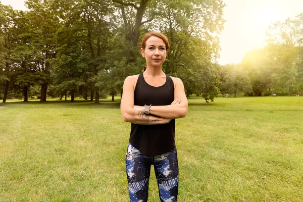 Güzel ve atletik bir kız. Koşmak için kıyafetleri var. Elleri göğsünde duruyor.