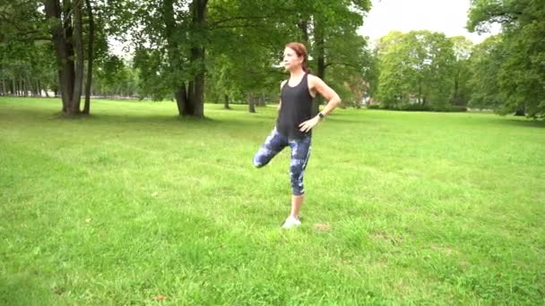 Νεαρή Αθλητική Γυναίκα Άσκηση Στο Πράσινο Πάρκο Πριν Από Τρέξιμο — Αρχείο Βίντεο