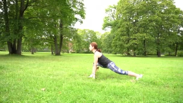 緑の公園で練習をしている若いスポーツ女性 — ストック動画